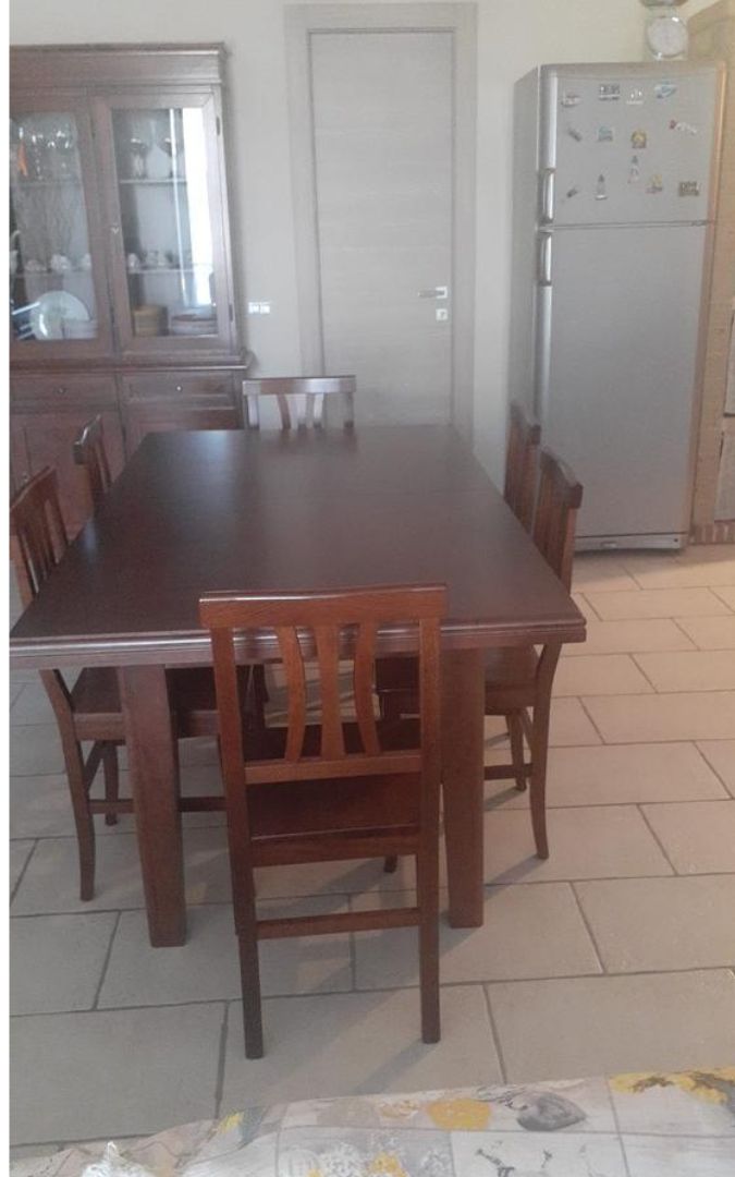 Tavolo da pranzo fratino allungabile color noce scuro con sedie abbinate in ambiente domestico.